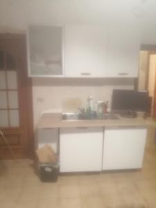 a kitchen with white cabinets and a counter top at The cat's rooms in Genoa