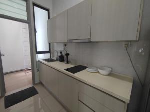 a kitchen with white cabinets and a counter top at 2Bedroom 5 Mins to MidValley 10 Mins to CIQ in Johor Bahru