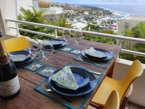 una mesa con copas y platos y una botella de vino en BLUE SUMMER T3 - vue sur mer - Saint Gilles les Bains, en Saint-Gilles-les-Bains