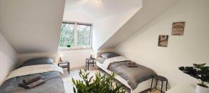 a attic room with two beds and a window at Chic Apartments in Altenstadt in Altenstadt