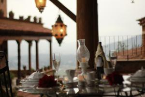 a table with wine glasses and plates on a balcony at Eco Hotel Ixhi in Pátzcuaro
