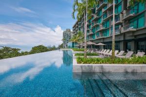 a swimming pool in front of a building at Angsana Teluk Bahang in Batu Ferringhi