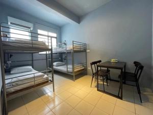a room with bunk beds and a table and a desk at Time Capsule in Taitung City