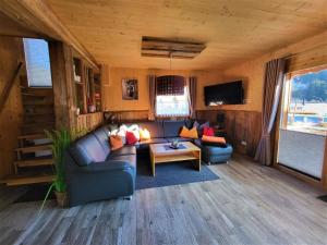 een woonkamer met een bank en een tv bij Kreischberg Chalet in Murau in Murau