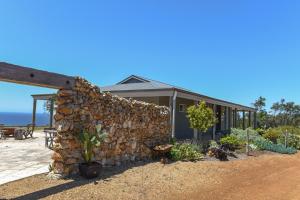 a stone wall next to a house with plants at Bremer Bay B&B in Bremer Bay