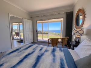 a bedroom with a bed and a view of the ocean at Bremer Bay B&B in Bremer Bay