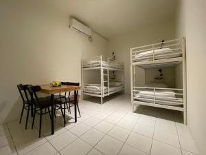 a room with a table and chairs and bunk beds at Time Capsule in Taitung City