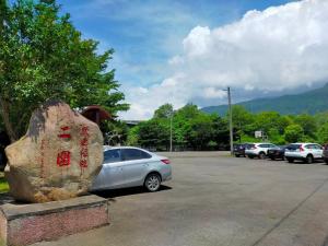 ein Auto parkt auf einem Parkplatz neben einem Felsen in der Unterkunft Qingyun Homestay in Toucheng
