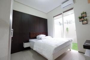 a bedroom with a large white bed with a wooden headboard at Villa Brassia - 3 Bedrooms 