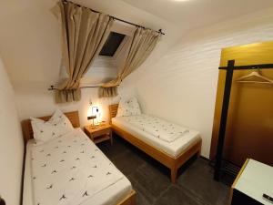 2 camas en una habitación pequeña con cortinas en Murperle en Sankt Michael im Lungau