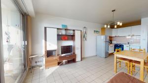 eine Küche und ein Esszimmer mit einem Tisch und einem Kühlschrank in der Unterkunft Face au Port de SAINT GILLES CROIX DE VIE in Saint-Gilles-Croix-de-Vie