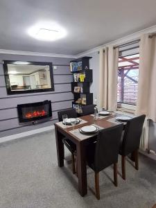 comedor con mesa y chimenea en Skye View Cottage, en Portree