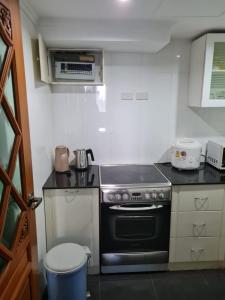 a small kitchen with a stove and a trash can at Omni Tower 2 Bed Room Sukhumbit Best Apartment in Bang Kapi