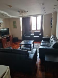 a living room with black couches and a table at Omni Tower 2 Bed Room Sukhumbit Best Apartment in Bang Kapi