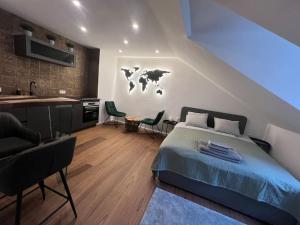 a bedroom with a bed and a kitchen with a world on the wall at Tiny Wellness Apartment in Graz