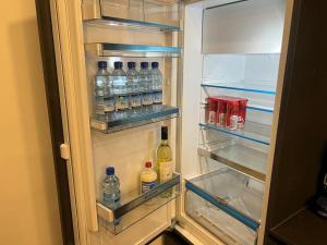 um frigorífico aberto cheio de garrafas de água e bebidas em Tiny Wellness Apartment em Graz