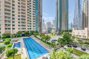 - une vue sur la piscine située dans une ville dotée de grands bâtiments dans l'établissement Maison Privee - Radiant Urban Retreat with Iconic Burj Khalifa Vws, à Dubaï