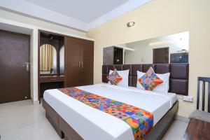 FabExpress Kanha Classic في كانبور: غرفة نوم مع سرير أبيض كبير مع وسائد ملونة