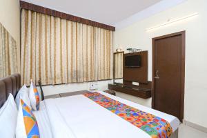 Habitación de hotel con cama y TV en FabExpress Kanha Classic, en Kānpur