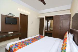 um quarto com uma cama e uma televisão de ecrã plano em FabExpress Kanha Classic em Kanpur