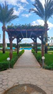 drewniany łuk z palmami w parku w obiekcie Chillax The View Resort w Szarm el-Szejk