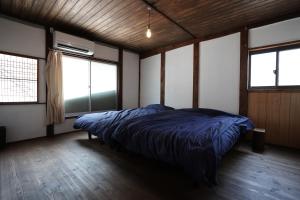a bedroom with a bed in a room with windows at 赭Soho Yunotsu Old Village Inn & Bar in Ōmorichō