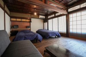 a living room with two beds and a couch at 赭Soho Yunotsu Old Village Inn & Bar in Ōmorichō