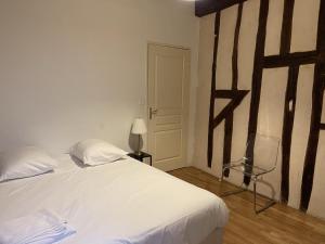 - une chambre avec un lit blanc, une chaise et une lampe dans l'établissement Appartement Le Coche d'Eau Auxerre Les Quais, à Auxerre