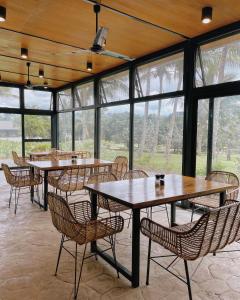 a dining room with tables and chairs and windows at Gunita Villas in Santo Tomas