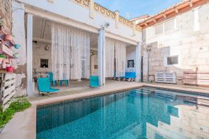 an indoor swimming pool with blue chairs in a house at Townhouse Can Miquel in Sa Pobla