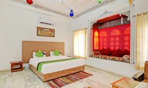 a bedroom with a bed and a red curtain at Treebo Trend Khakhri Haveli in Udaipur