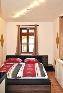 Un dormitorio con una cama con almohadas rojas y una ventana en Ferienwohnung Mörlenbach Altstadt, en Mörlenbach