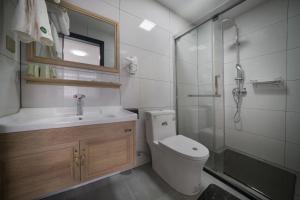 a bathroom with a toilet and a shower and a sink at Qianxun Tea House & Homestay in Wuyishan