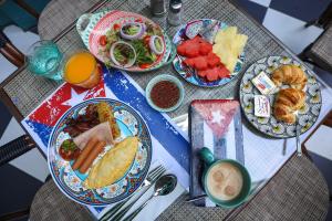 a table topped with plates of food and fruit at Quba by Montraj Pattaya, previously The Quba Hotel Pattaya in Pattaya