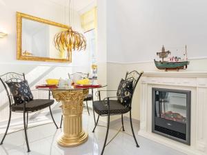 une salle à manger avec une table, des chaises et une cheminée dans l'établissement Haus Liebeskind - WG 4 "Gelbe Calla", à Binz