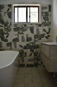 baño con bañera y pared con plantas en Haliaeetus@Hat, en Hat Head