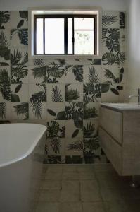 a bathroom with a tub and a wall with plants at Haliaeetus@Hat in Hat Head