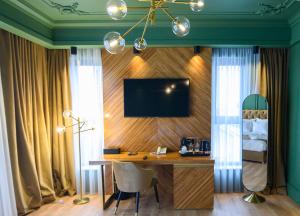 Cette chambre comprend un bureau et une télévision murale. dans l'établissement HOTEL VIENA, à Satu Mare