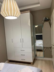 a bedroom with a white cabinet and a mirror at Alfa Toplu ulaşıma yakın Tam donanımlı şık daire in Istanbul