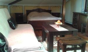 a bedroom with two beds and a table with a candle on it at Chuchura Family Hotel in Koprivshtitsa