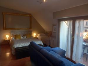 a bedroom with a bed and a couch and a window at With Free Parking - The Boheme Navigli Junior Suite - Quiet & comfy vintage Junior Suite with cozy balcony - 5th attic floor lift to 4th floor - metro' verde -green subway Porta Genova in Milan