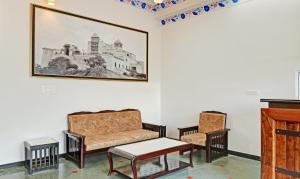 a living room with a couch and two chairs at Treebo Trend Khakhri Haveli in Udaipur