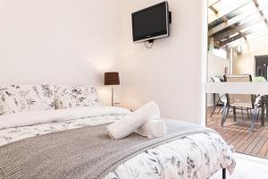 Schlafzimmer mit einem Bett und einem TV an der Wand in der Unterkunft Beach Retreat in Saint Leonards