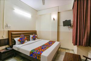 a bedroom with a bed and a tv in it at FabHotel Ashoka Inn in Kānpur
