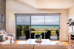 een woonkamer met uitzicht op de oceaan bij Beach Retreat in Saint Leonards