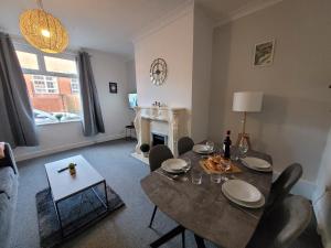 a living room with a table and chairs and a fireplace at Luke Stays - Rokeby Street in Lemington