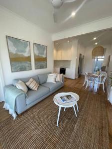 a living room with a couch and a table at Quarterdeck Lakes Entrance 2br *Waterfront* Apartment in Lakes Entrance