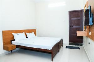 a bedroom with a bed and a tv in it at KKM International kk in Kanyakumari