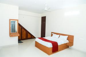a bedroom with a bed with a red blanket at KKM International kk in Kanyakumari