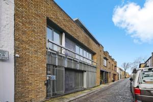 un edificio de ladrillo con balcón en una calle en Livestay-Camden Mews House with Private Roof Terrace en Londres